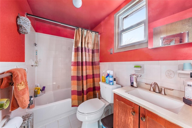 full bathroom with toilet, a wainscoted wall, vanity, tile patterned floors, and shower / bath combo