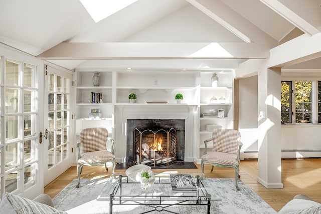 living room with a baseboard heating unit, vaulted ceiling with skylight, a fireplace with flush hearth, and wood finished floors