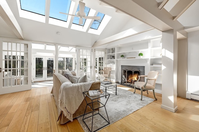 living room with light wood-style flooring, french doors, a skylight, and built in shelves