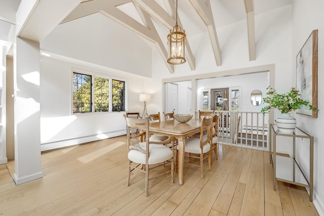 dining space featuring light wood-type flooring, beam ceiling, baseboard heating, and high vaulted ceiling