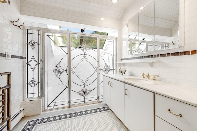 bathroom featuring a baseboard heating unit, tile walls, and vanity