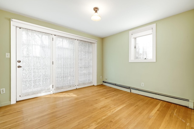 empty room featuring a baseboard radiator and wood finished floors