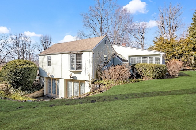 view of home's exterior with a yard, a chimney, and stucco siding