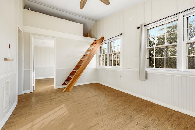 unfurnished room with wood finished floors, baseboards, and ceiling fan