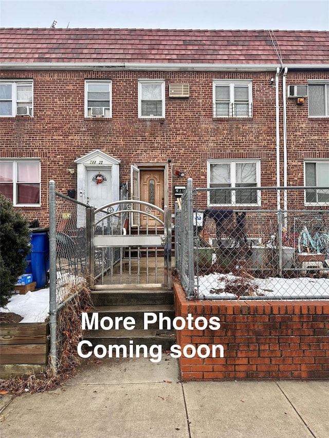 view of front of home featuring a fenced front yard, a gate, and brick siding