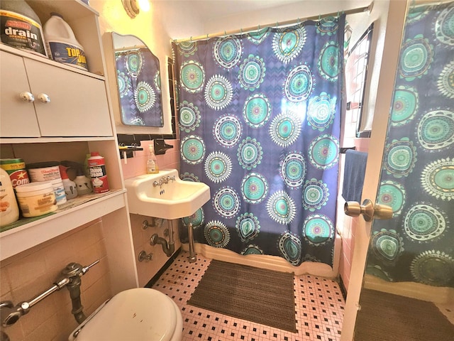 full bathroom with toilet, curtained shower, and a sink