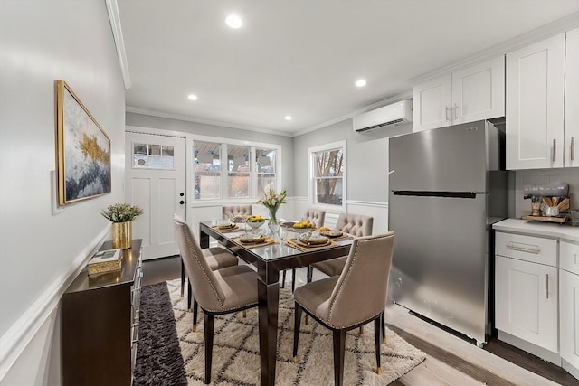 dining room with ornamental molding, light wood-type flooring, recessed lighting, and a wall mounted AC