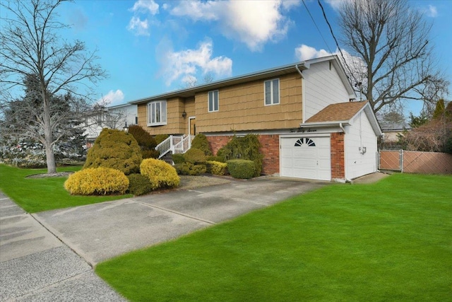 split foyer home with brick siding, fence, driveway, and a front lawn