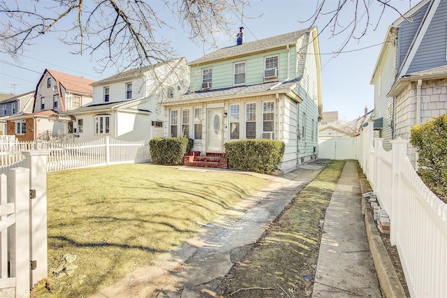 rear view of house with entry steps, a fenced backyard, a yard, a residential view, and a chimney