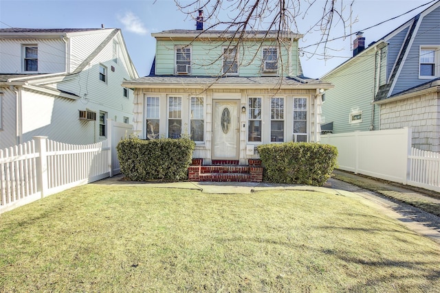 view of front facade featuring entry steps, fence, and a front lawn