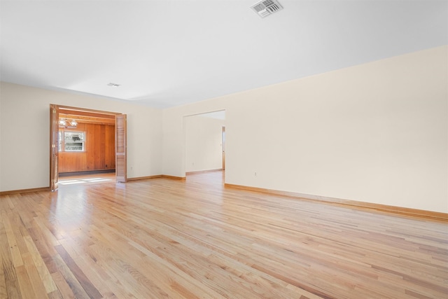 unfurnished room with baseboards, visible vents, and light wood-style floors