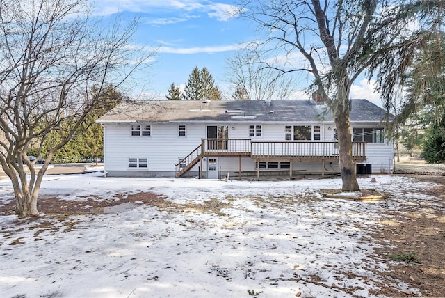 snow covered rear of property with stairs, cooling unit, and a wooden deck