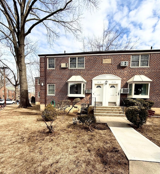 view of front facade featuring cooling unit and brick siding