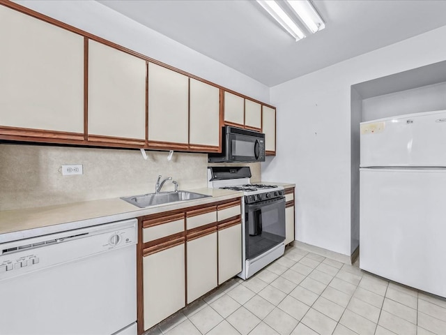 kitchen featuring white appliances, light countertops, a sink, and white cabinets