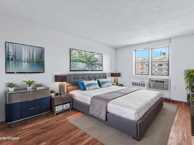 bedroom with dark wood-style floors, radiator heating unit, and a textured ceiling