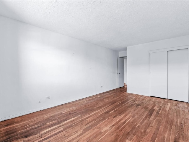 unfurnished bedroom featuring hardwood / wood-style flooring, a closet, and a textured ceiling