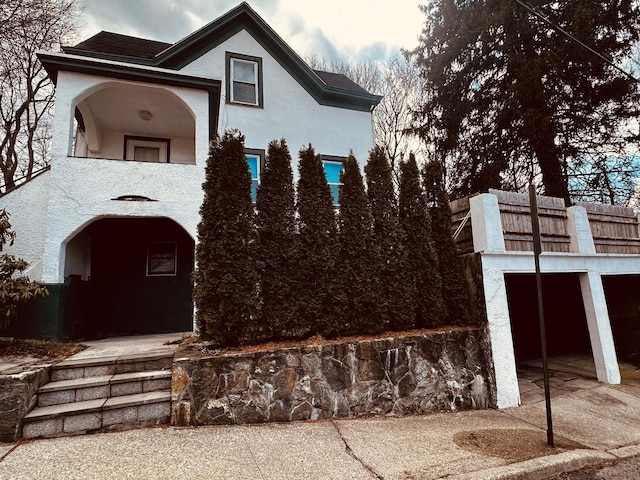 view of front of house with a balcony and stucco siding