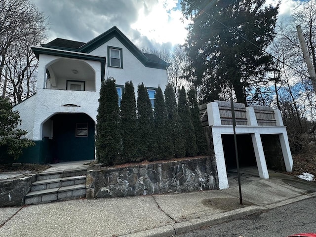 view of front of home featuring a balcony and stucco siding