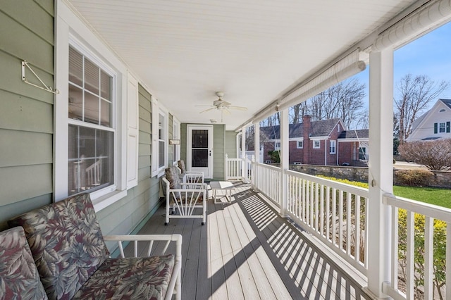 deck featuring a porch, a residential view, and a ceiling fan