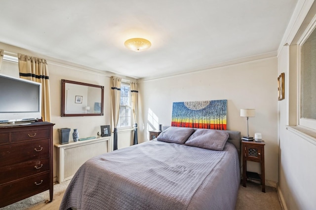 bedroom with baseboards and light colored carpet