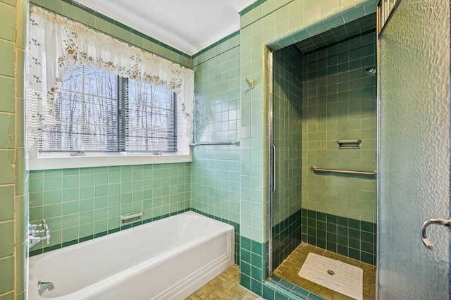 full bathroom with a stall shower, tile walls, and a bath