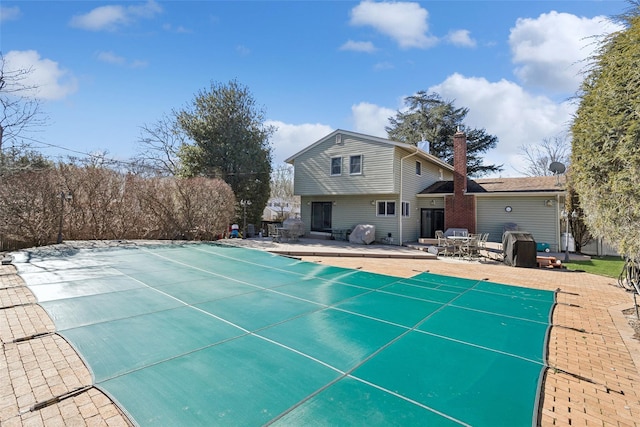 view of pool featuring a patio area, a covered pool, and area for grilling