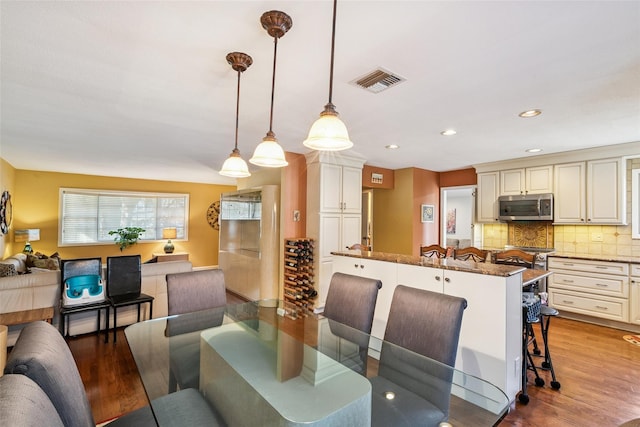 dining area featuring recessed lighting, visible vents, and wood finished floors