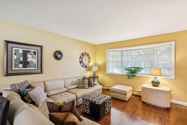 living area with a baseboard heating unit, baseboard heating, hardwood / wood-style flooring, and baseboards