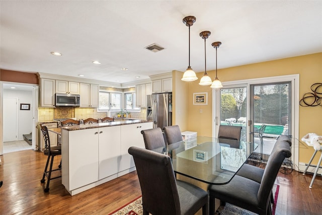 dining room with dark wood-style flooring, recessed lighting, visible vents, and a healthy amount of sunlight