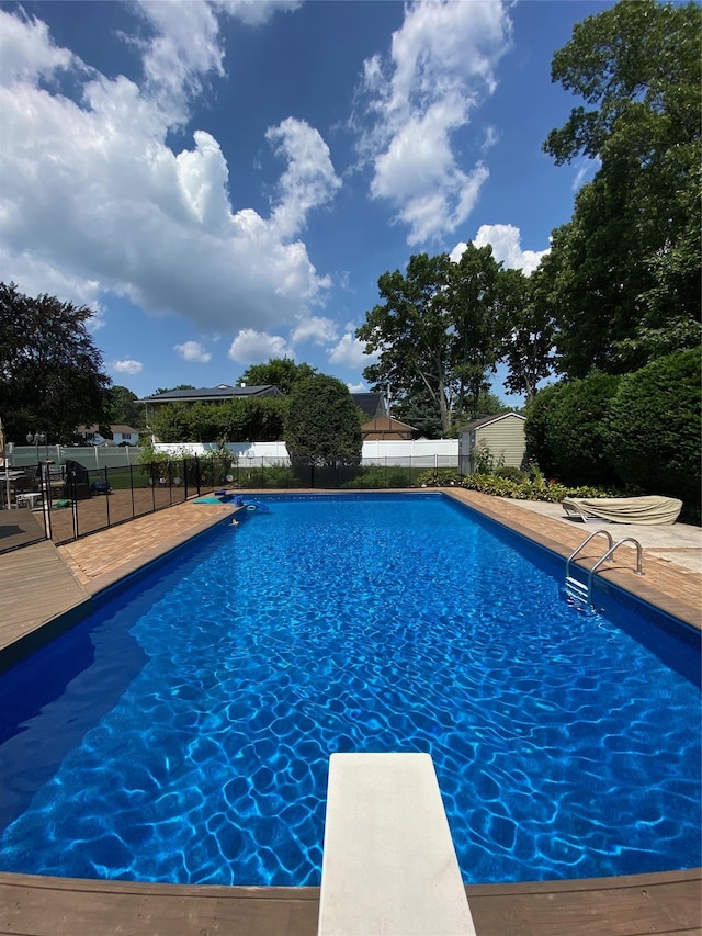 view of pool featuring a fenced in pool, fence, and a diving board