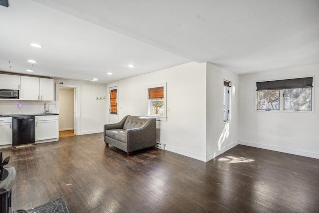 unfurnished room with a wealth of natural light, dark wood finished floors, and baseboards