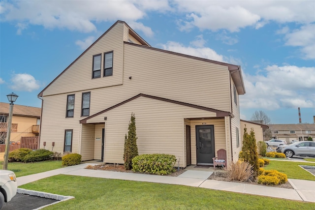 townhome / multi-family property featuring a front lawn