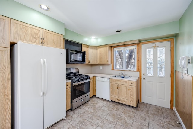 kitchen with recessed lighting, white appliances, a sink, light countertops, and light brown cabinetry