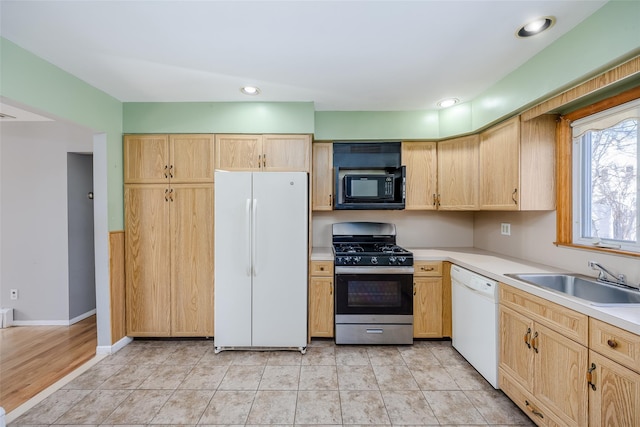 kitchen with light tile patterned floors, recessed lighting, light countertops, a sink, and white appliances