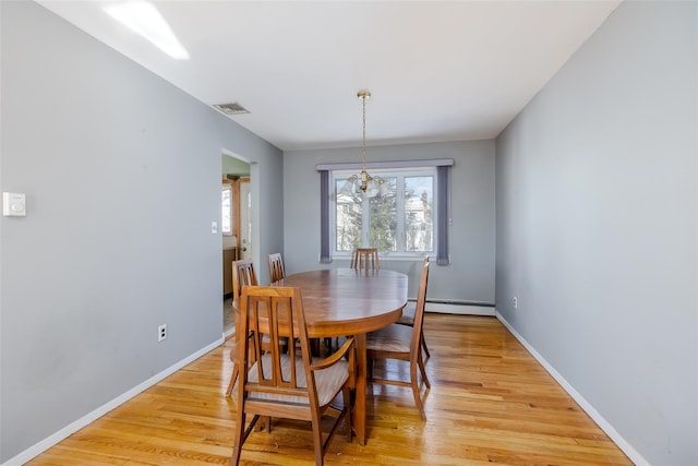 dining space featuring light wood-type flooring, visible vents, baseboards, and a baseboard radiator