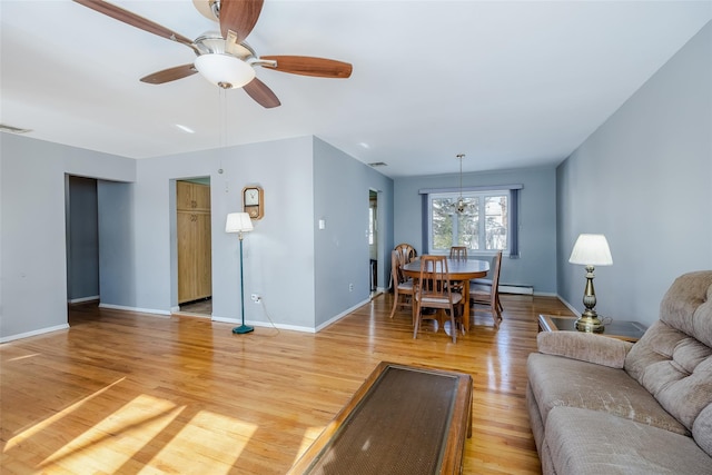 living room with a ceiling fan, baseboards, visible vents, and light wood finished floors