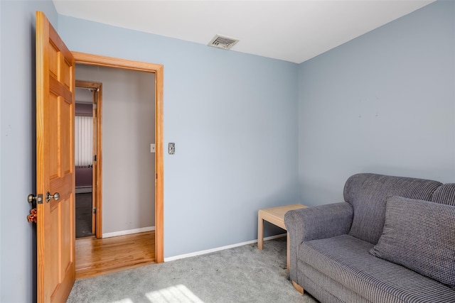 sitting room featuring light colored carpet, visible vents, and baseboards