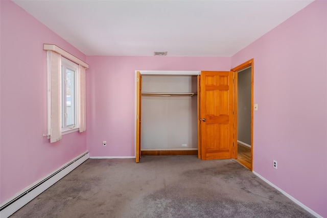 unfurnished bedroom with a closet, visible vents, baseboard heating, carpet flooring, and baseboards