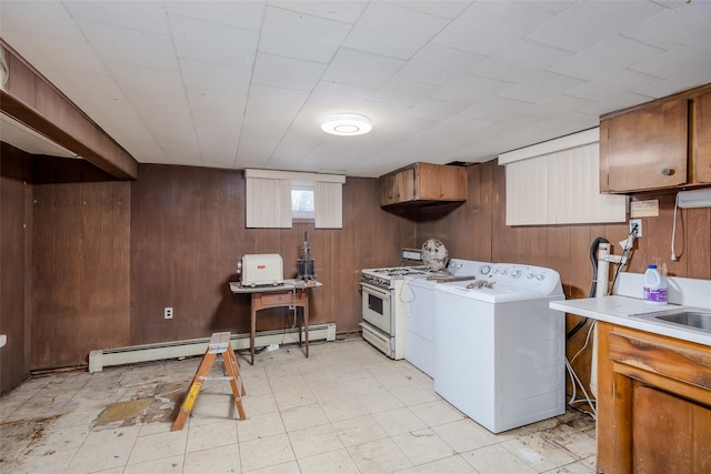 washroom with washer and clothes dryer, light floors, baseboard heating, wood walls, and laundry area