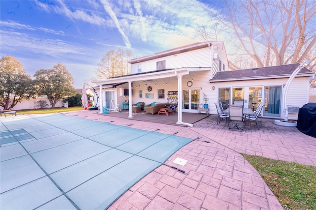 rear view of house with a fenced in pool and a patio area