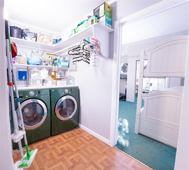 washroom with laundry area, washing machine and clothes dryer, and baseboards