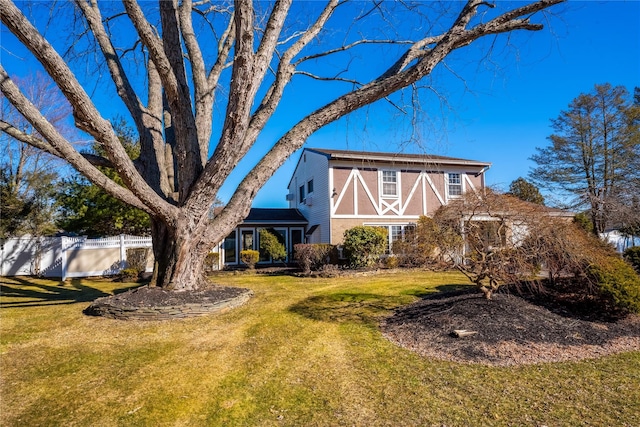 view of front facade with a front yard, fence, and a barn