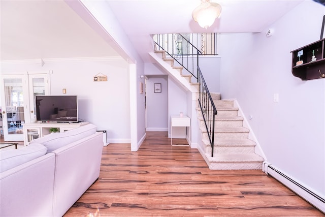 interior space with a healthy amount of sunlight, stairway, baseboard heating, and wood finished floors