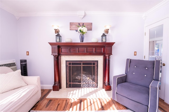 sitting room featuring baseboards, wood finished floors, a high end fireplace, and crown molding