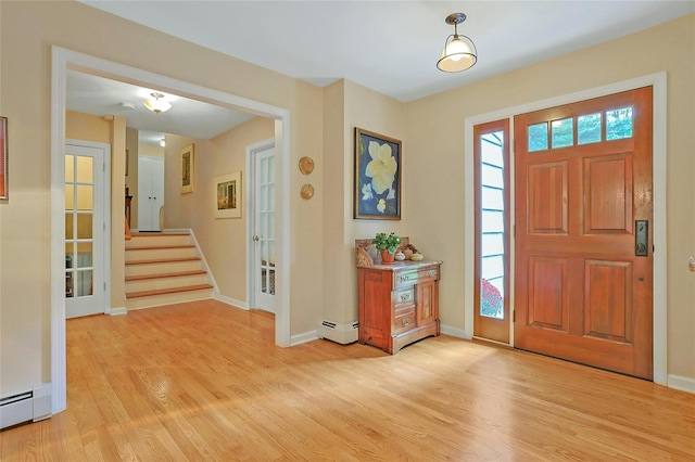 entryway with light wood finished floors, stairway, a baseboard radiator, and baseboards