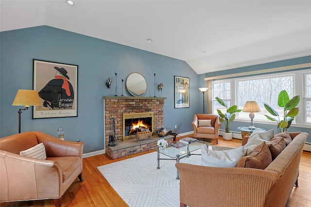 living room featuring a fireplace, lofted ceiling, baseboard heating, wood finished floors, and baseboards