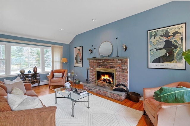 living room with baseboards, lofted ceiling, wood finished floors, baseboard heating, and a brick fireplace