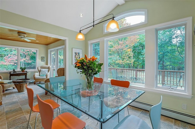 dining room with lofted ceiling, plenty of natural light, and stone tile flooring