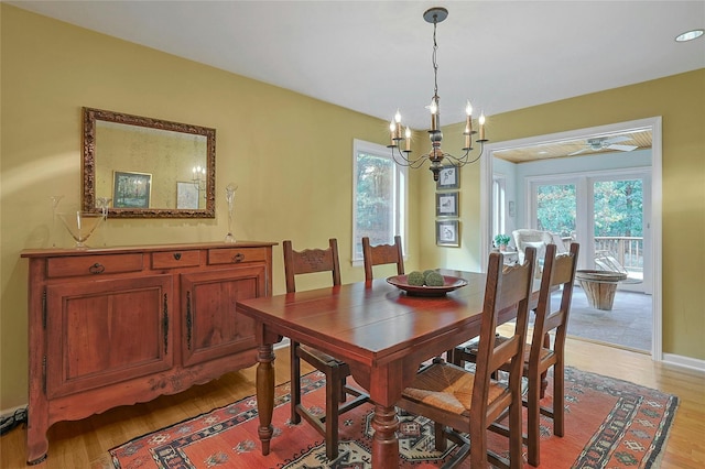 dining space with light wood finished floors, baseboards, and a chandelier