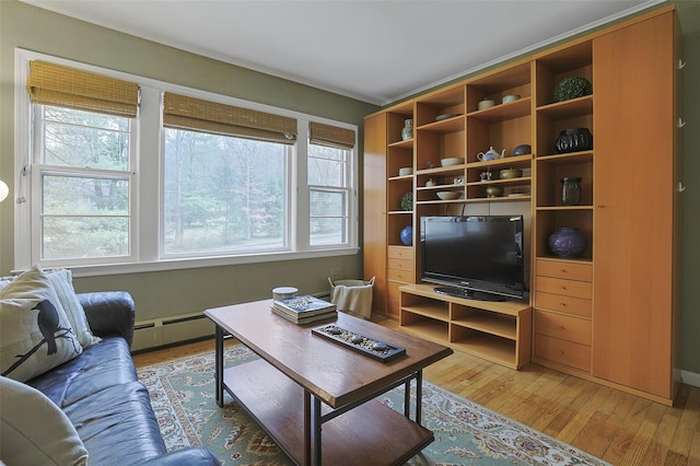 living area with light wood-style flooring and baseboard heating